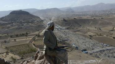 مقاتل حوثي يراقب من أعلى جبل أثناء تجمع لأنصار مليشيا الحوثي 24 يناير 2013 في حزيز